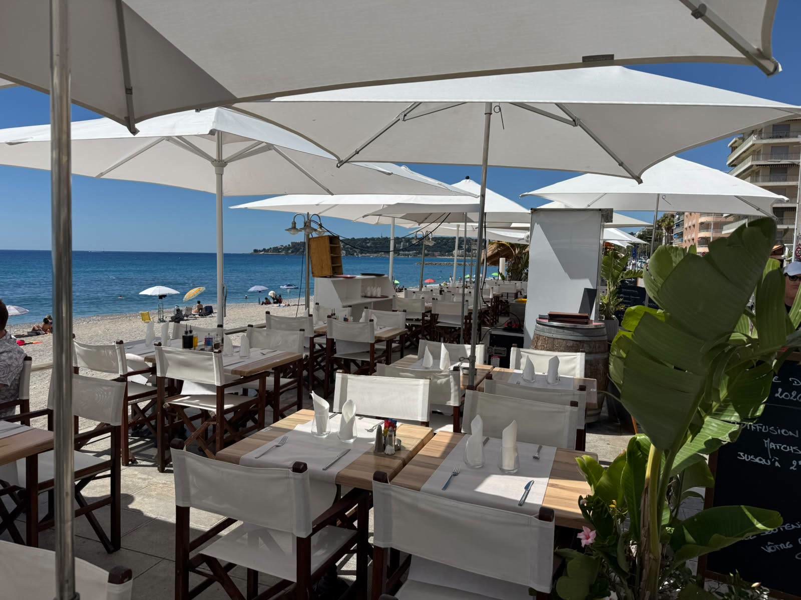 Terrasse de L'Onda avec parasols blancs face à la mer à Menton
